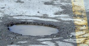 water filled pot hole in the middle of the street